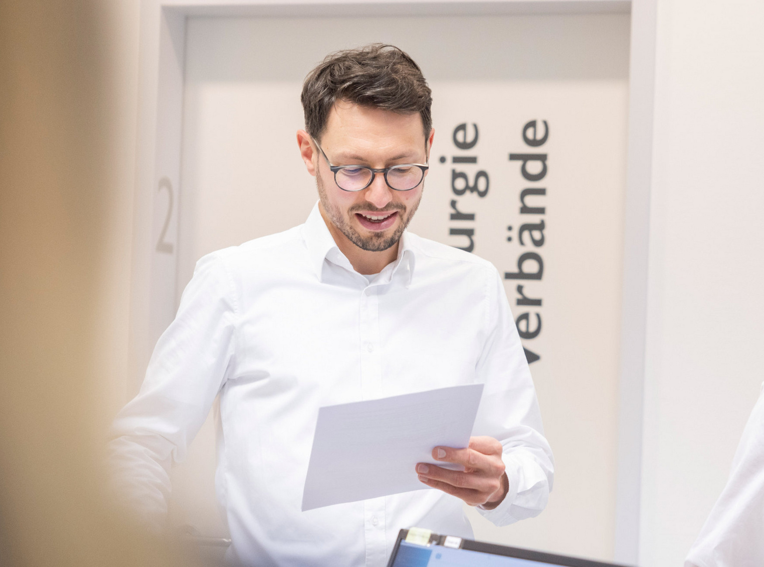 Internistische Hausarztpraxis Dr. Andreas Kirsner Arzt prüft Dokument Arzt prüft ein Dokument am Empfang einer Praxis