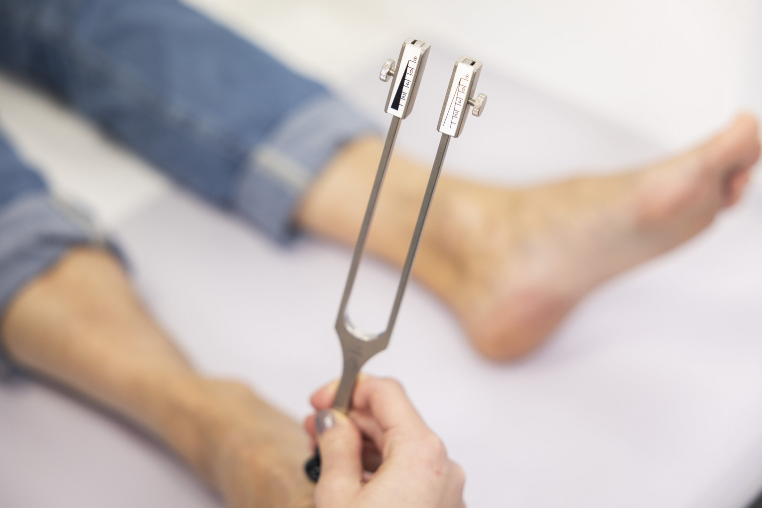 Füße von Patient sind zu sehen im Vordergrund Messgerät diabetischer Fuß